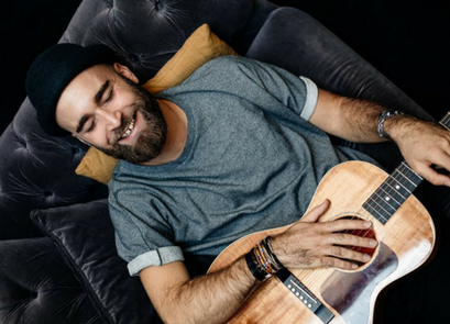 Caruso, guitare en mains et sourire aux lèvres